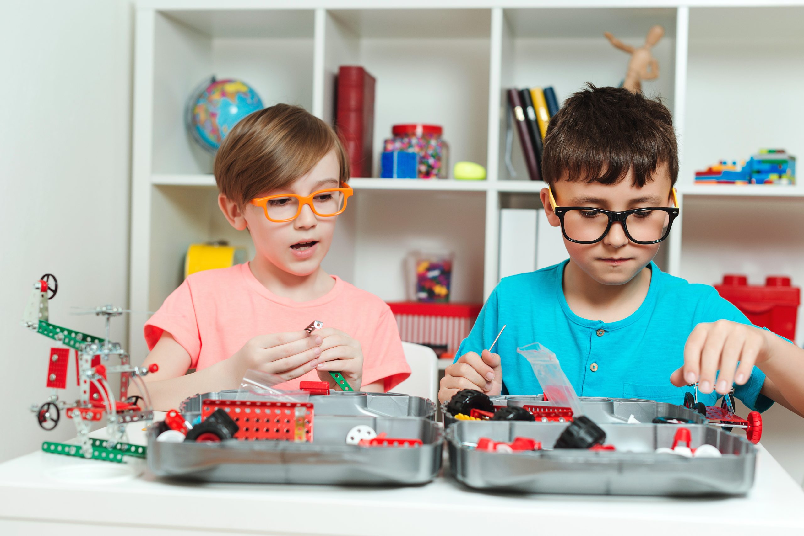Kids building robots at robotics school lesson. Students creating metal construction at classroom.